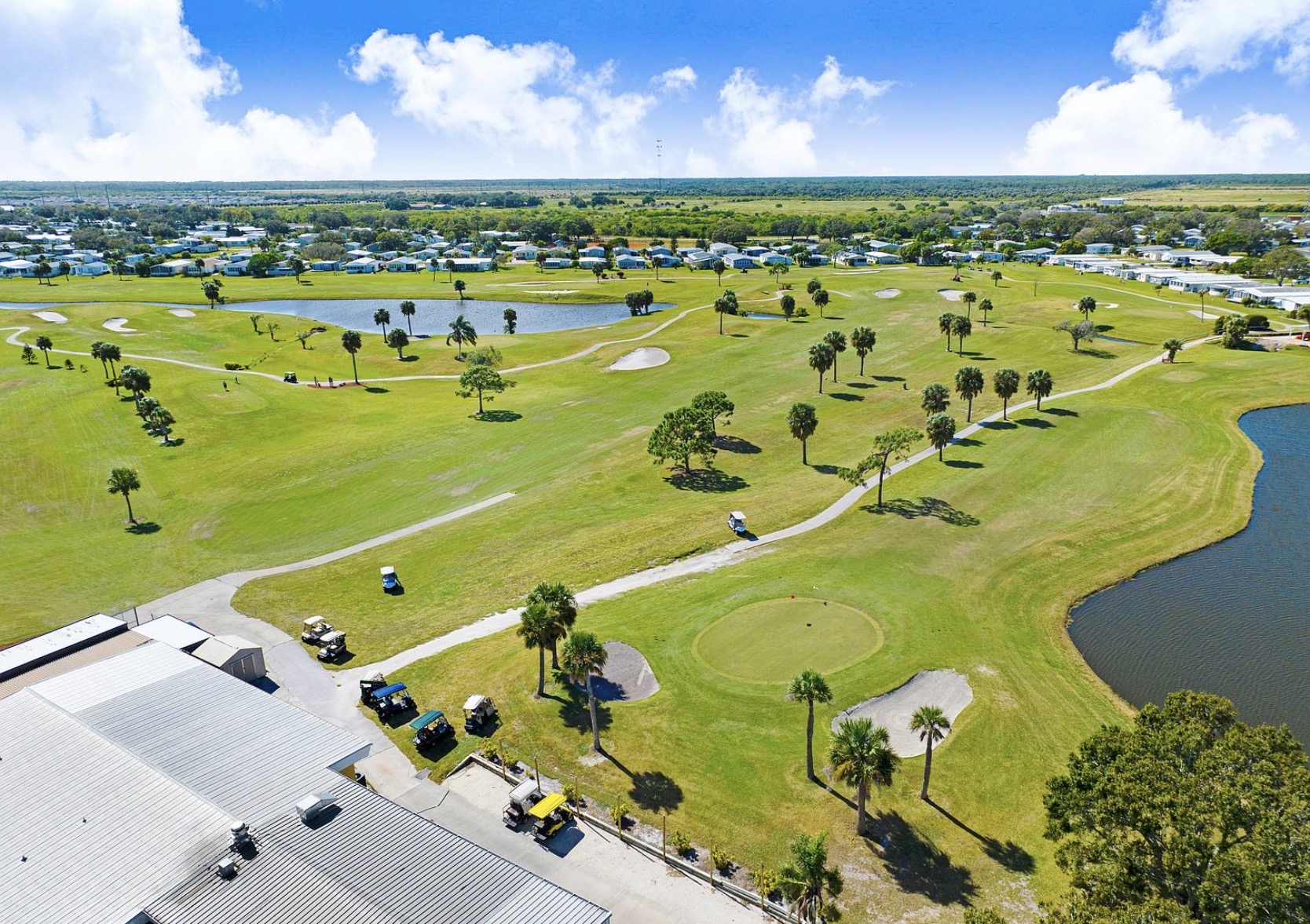 Aerial view of the golf course with palms, ponds and golf carts